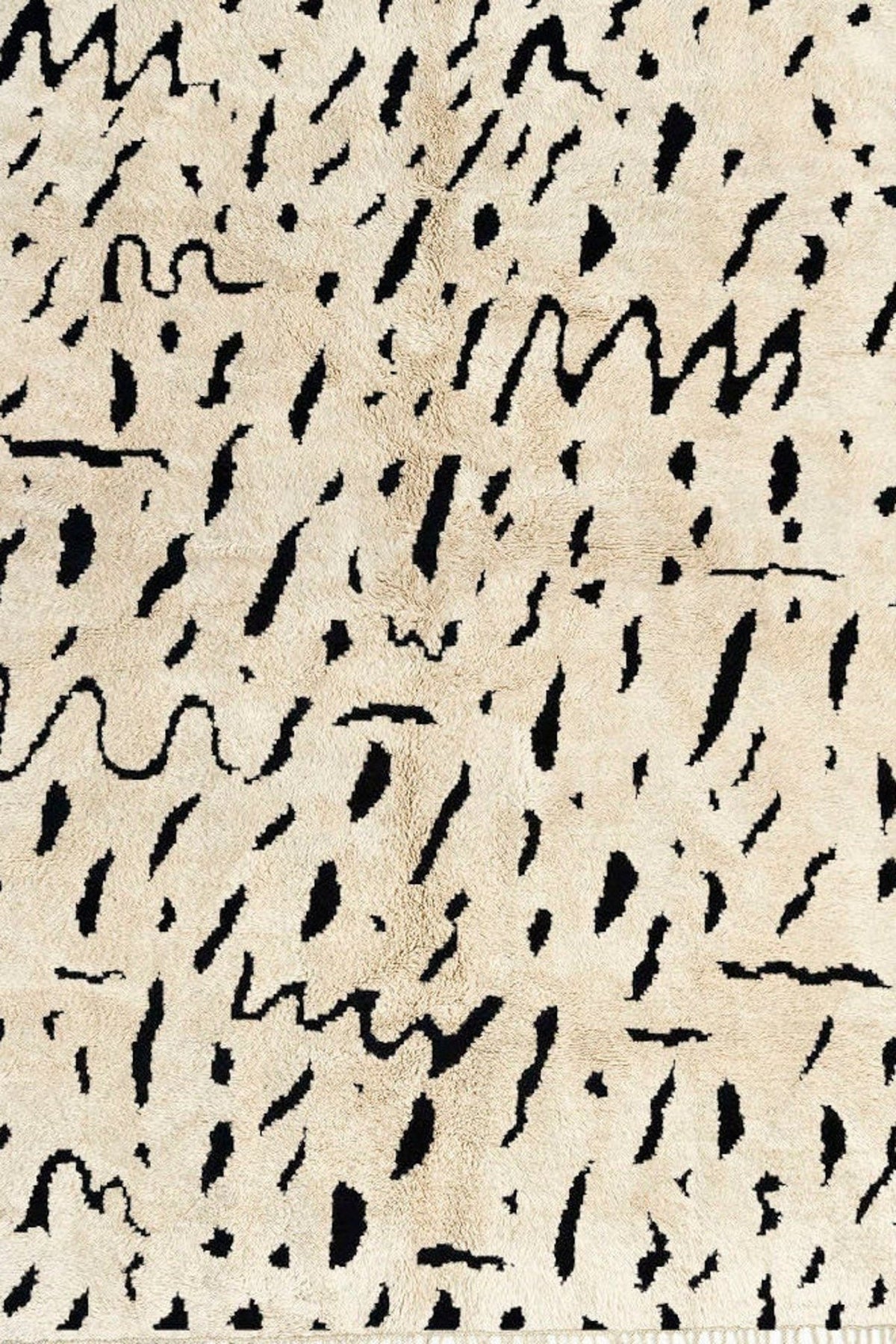 Close-up detail of the taupe speckled Moroccan rug highlighting its textured abstract pattern.