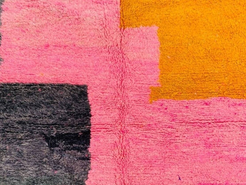 Detail close-up of the textured surface and color blocks of the pink and black Azilal Moroccan rug.