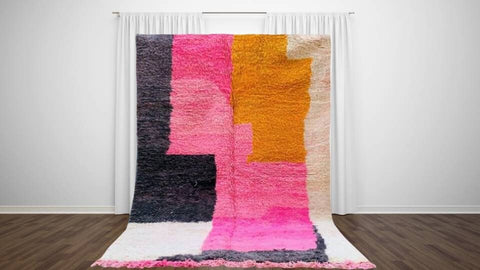 Lifestyle view of the pink and black color block Azilal Moroccan rug with geometric design.