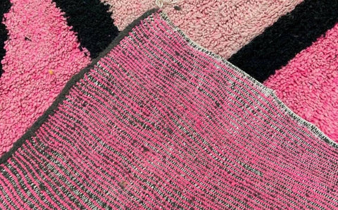 Lifestyle view showcasing the large pink and black color block Azilal Moroccan rug's abstract pattern.