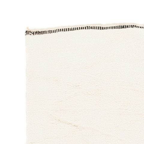 Close-up detail showing black accents on the cream and gray Moroccan area rug.