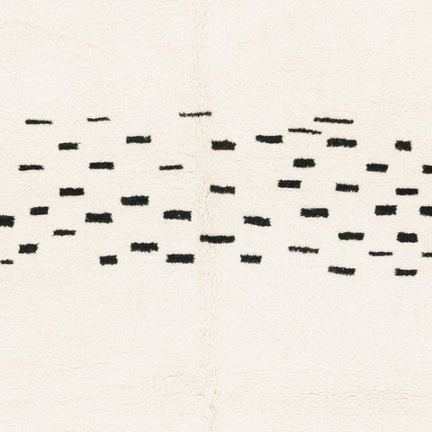 Detail view of the edge and black patterns on the cream Moroccan rug.