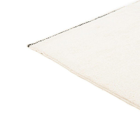Side view of the cream and gray Moroccan area rug featuring a Berber design.