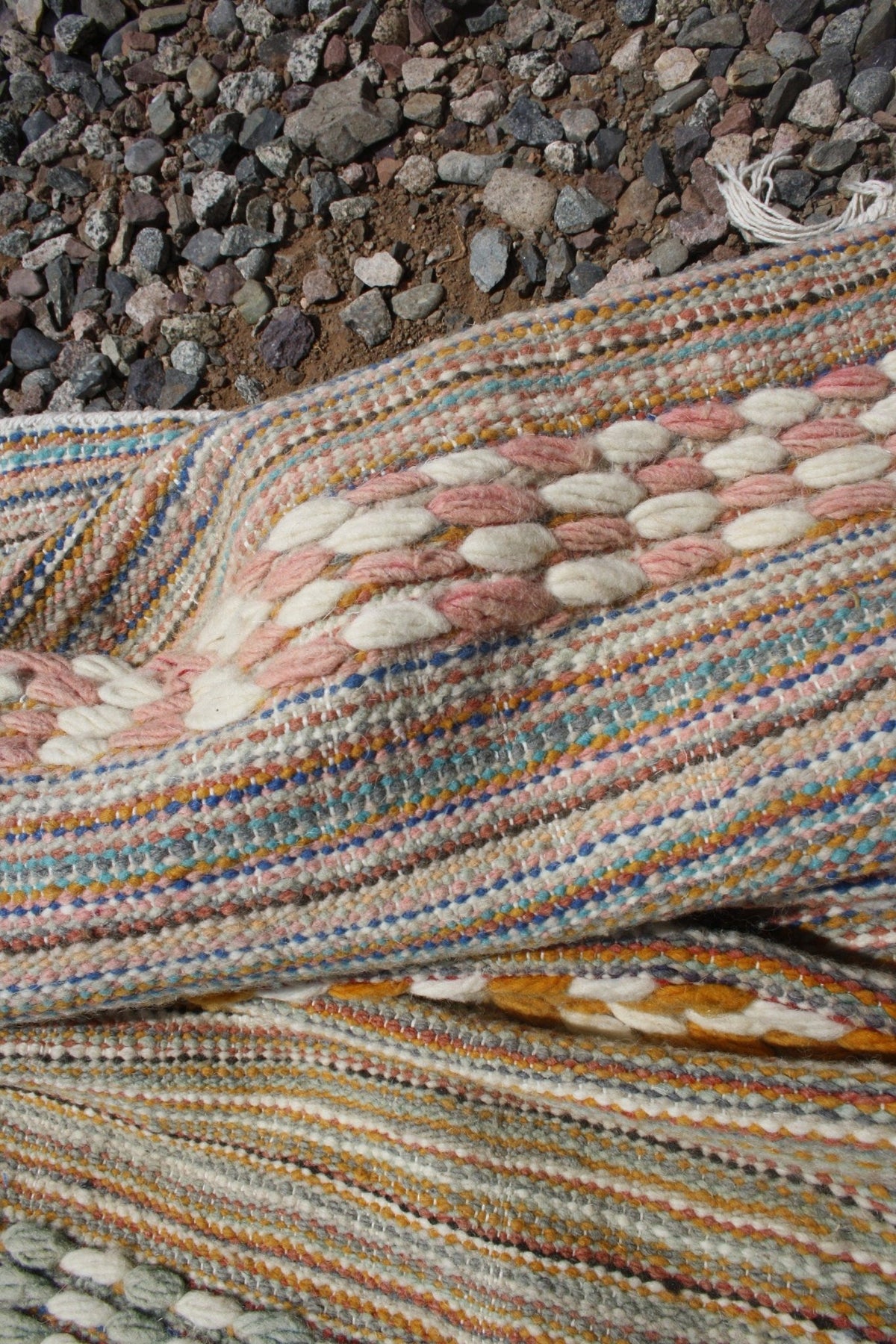 Close-up of geometric patterns on a brown and beige Moroccan kilim rug with a woven texture.