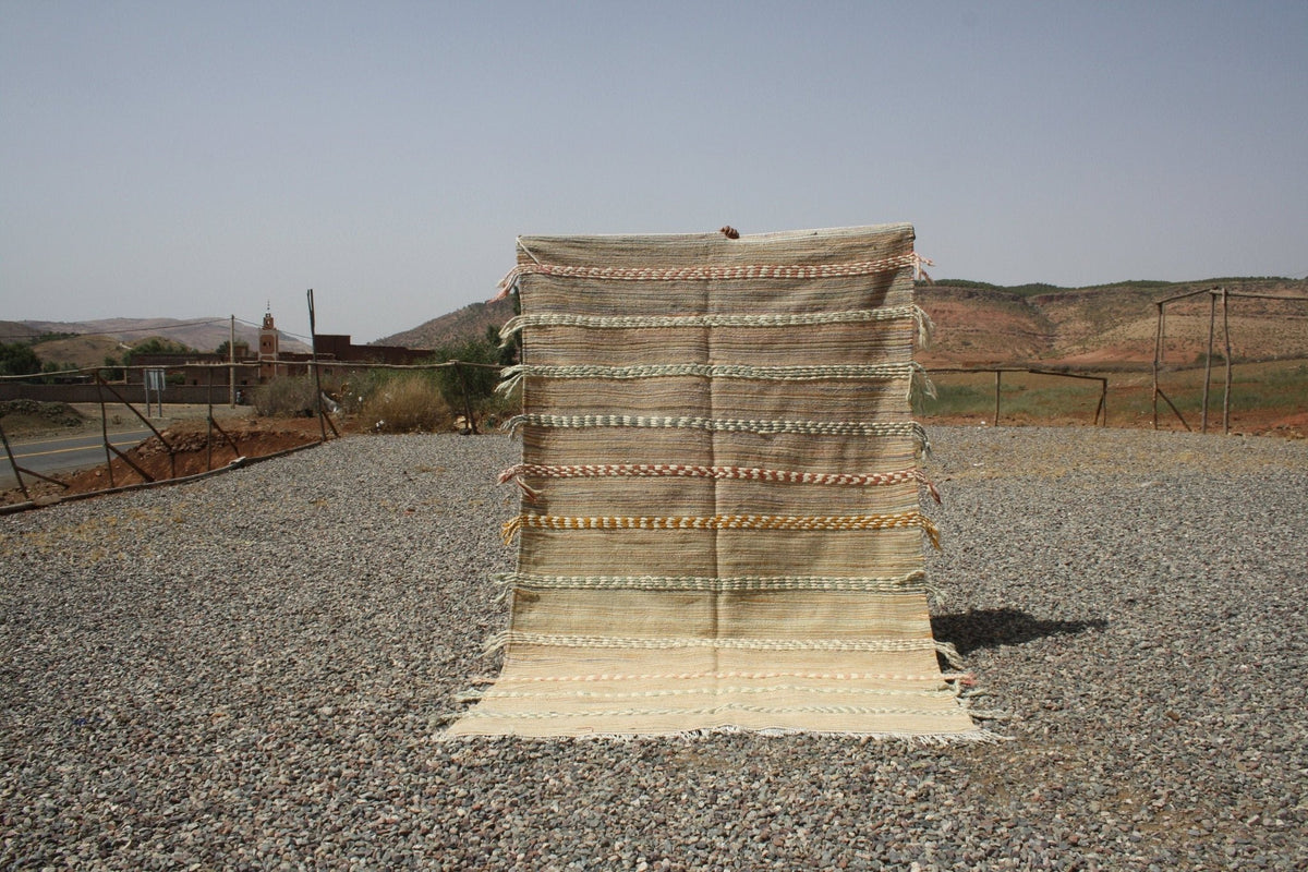 Lifestyle shot of a beige and brown Moroccan kilim rug with a textured weave.
