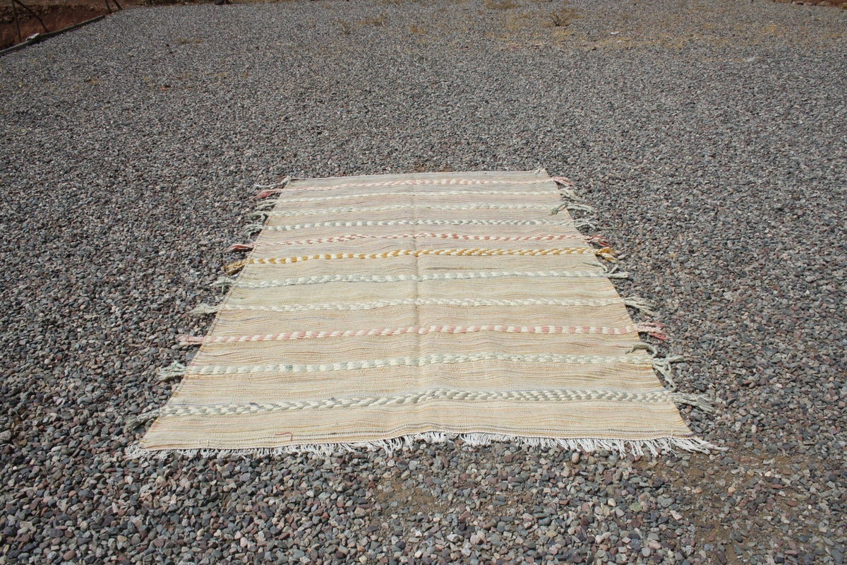 Lifestyle view of a large beige and brown Moroccan kilim rug showcasing its textured surface.