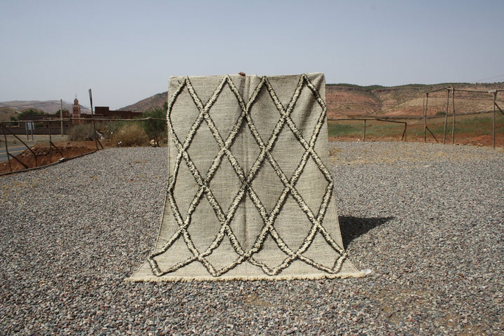 Lifestyle shot of a beige and brown Moroccan kilim rug with a geometric pattern.