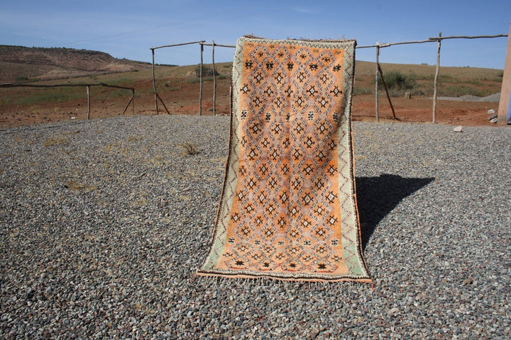 Lifestyle shot of a vintage kilim rug featuring an orange and brown textured pattern.