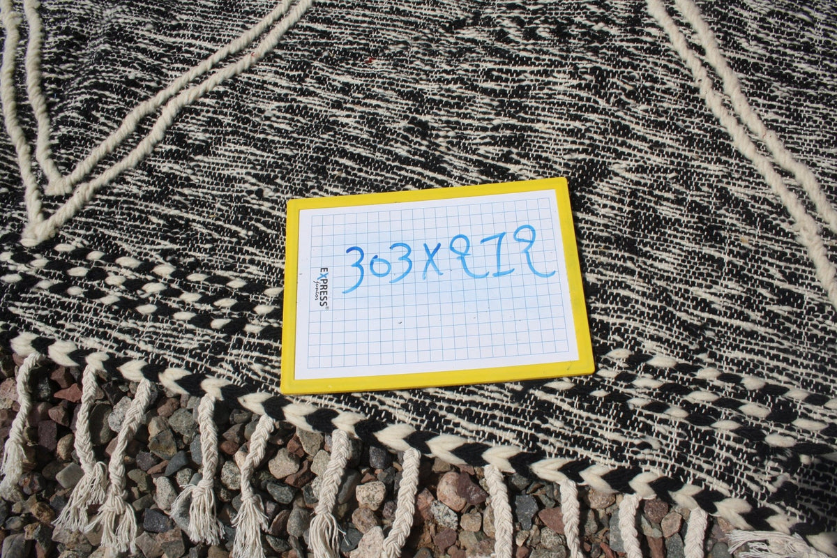 Close-up detail of the black and white textured weave with fringe on the Moroccan kilim rug.