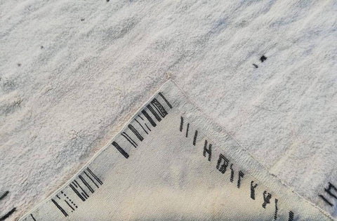 Angled view of the abstract Moroccan rug displaying its patterned edges.