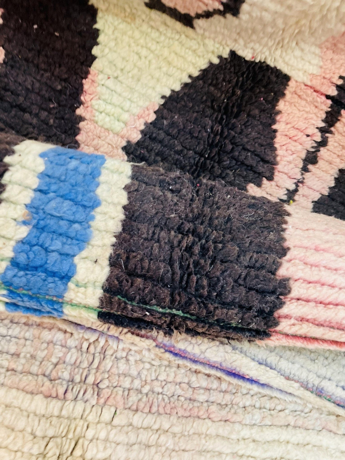 Lifestyle view of a vintage Moroccan rug featuring abstract patterns in beige, blue, and black.