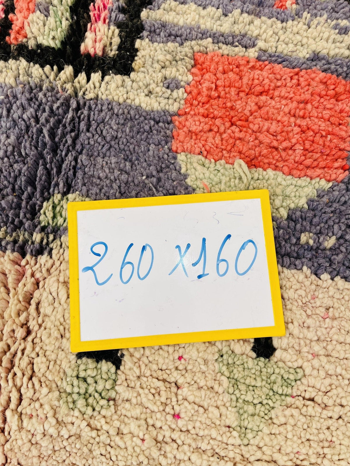 Detail shot of a price tag on a Moroccan rug with handwritten text.