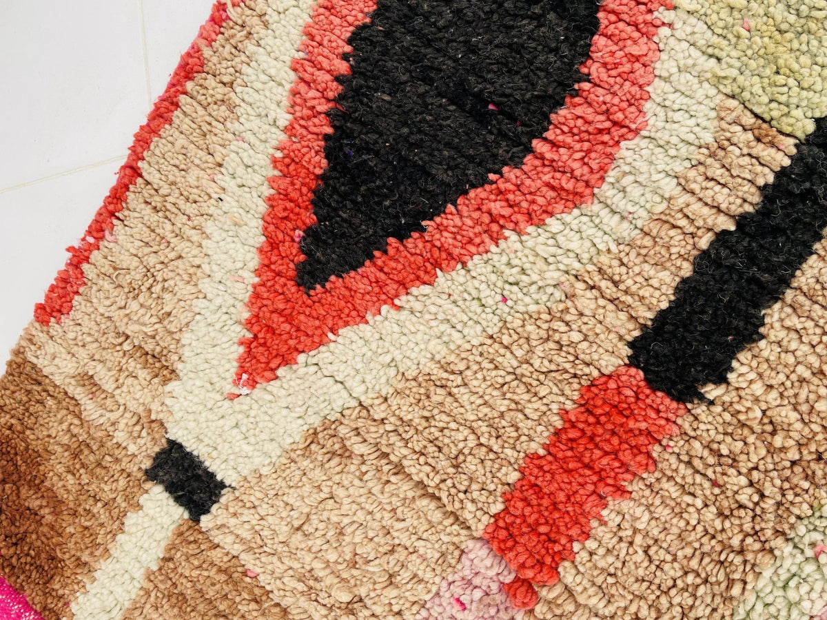 Detail shot of a Moroccan rug featuring geometric patterns in red and black.