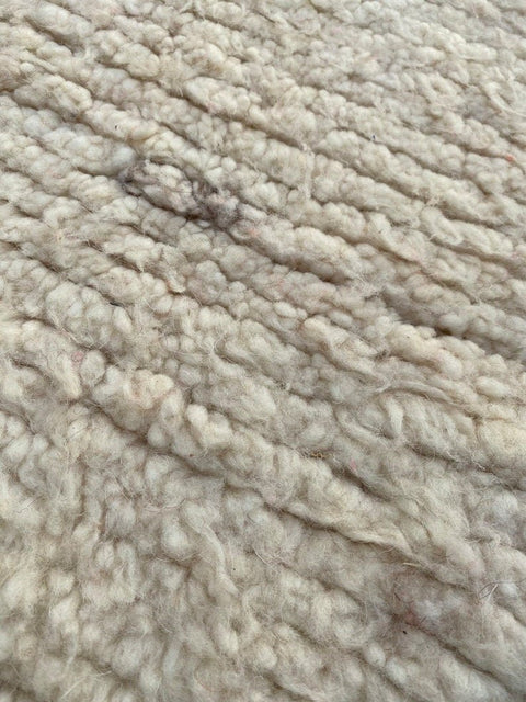 Close-up of the beige textured surface of the Beni Ourain rug.