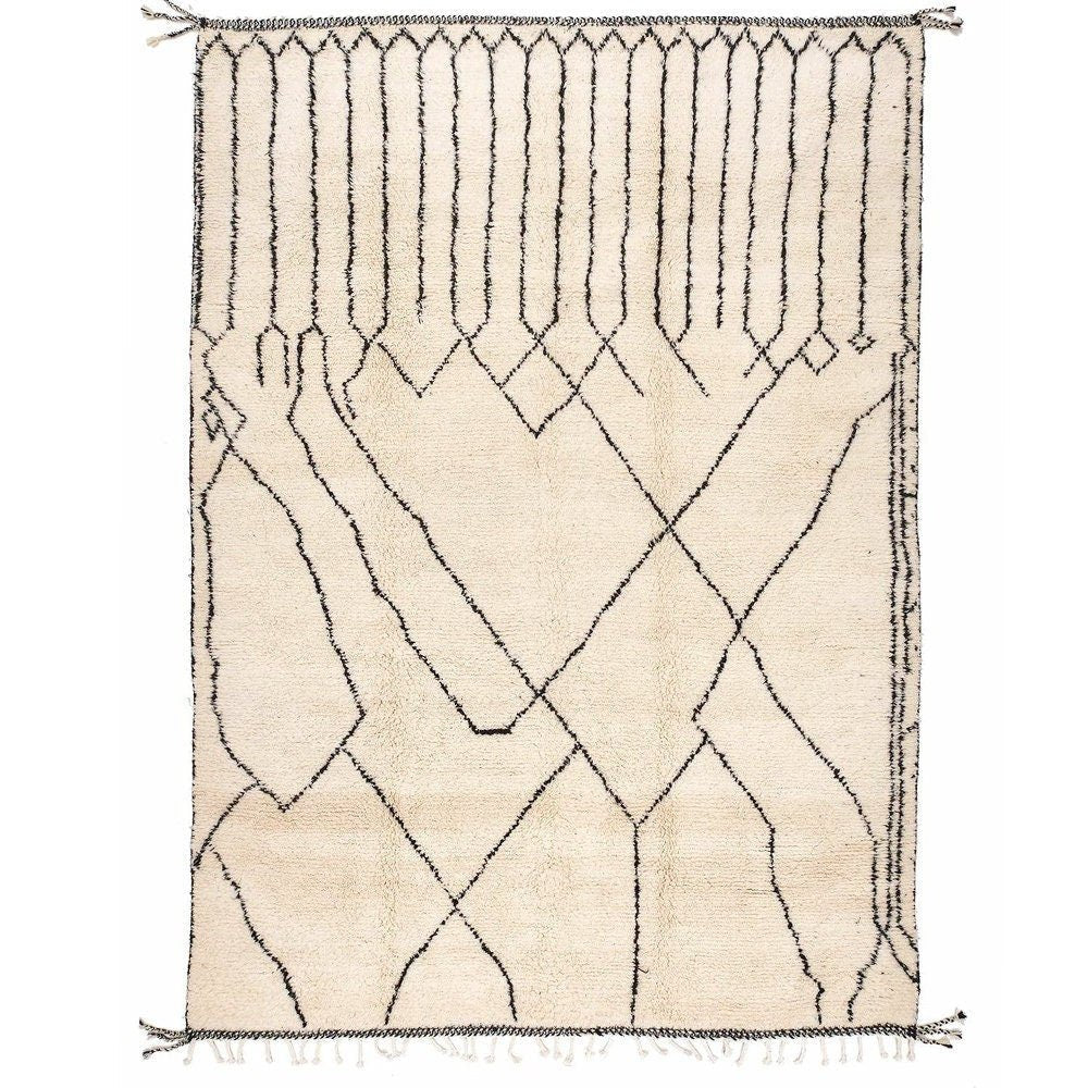 Detail view of an off-white Beni Ourain rug featuring a geometric pattern and fringe edges.