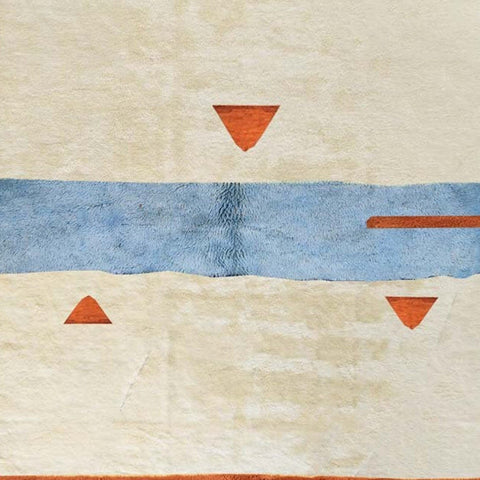 Side view of a cream, blue, and rust geometric Moroccan rug showcasing its abstract design.