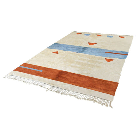Side shot of a cream, blue, and rust geometric Moroccan rug highlighting its abstract geometric patterns.