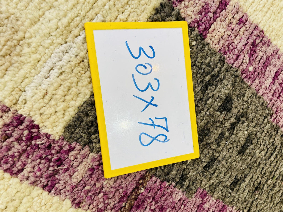 Close-up view of the Moroccan runner rug showing cream, purple, and green colors in an abstract pattern.