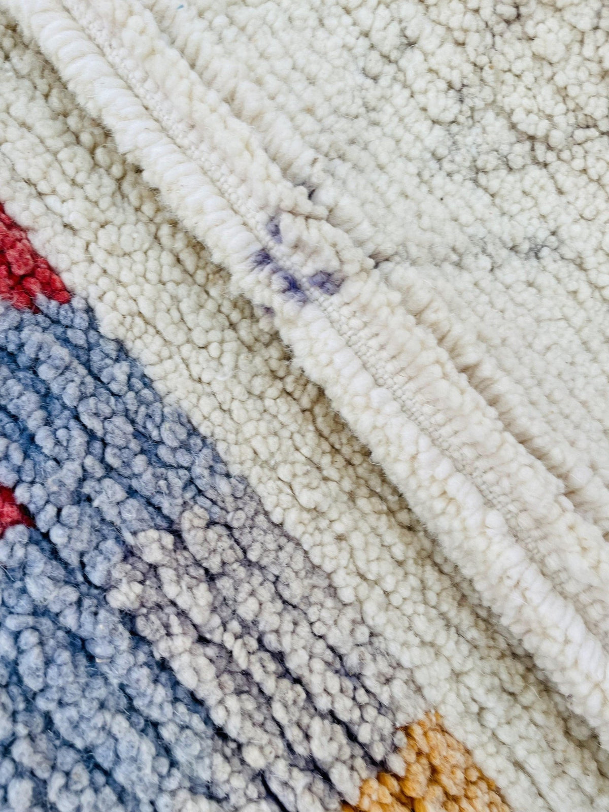 Close-up detail of the woven texture and colorful patterns of the rug.