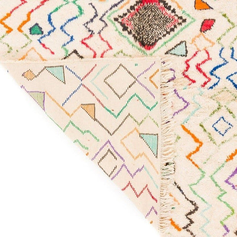 Side view of a multicolor Moroccan rug featuring geometric patterns and a thick pile.