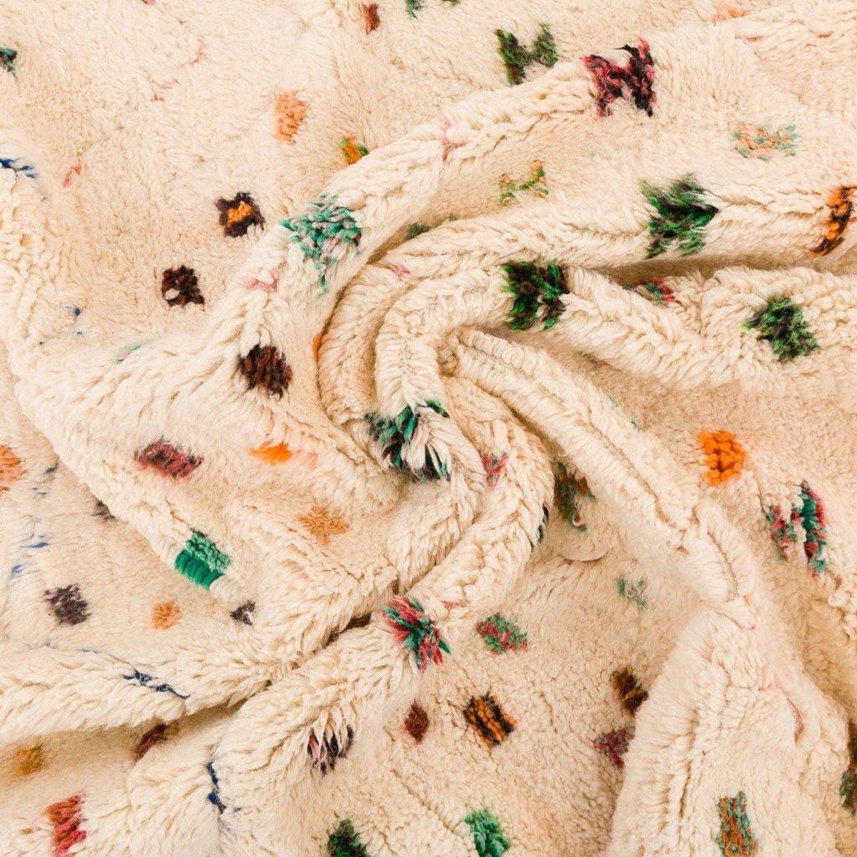 Detail shot of a colorful area rug with a textured surface and polka dot pattern.