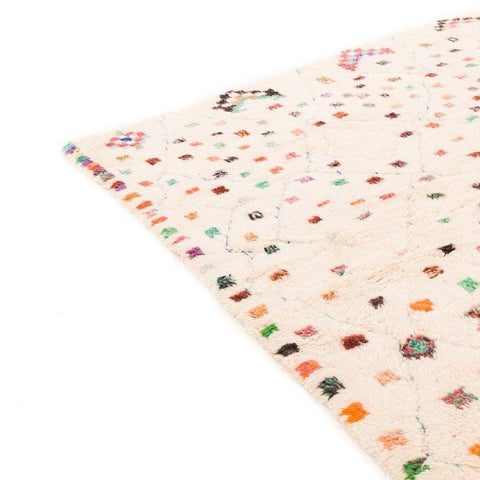 Detail shot of a colorful patterned rug showcasing geometric patterns in cream and multicolor.