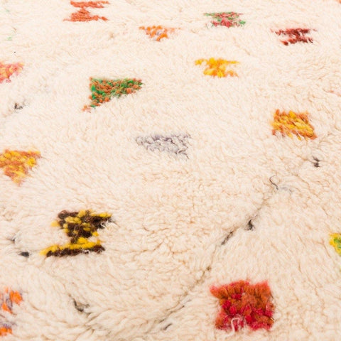 Close-up of a colorful patterned rug with colorful dots and a soft texture.