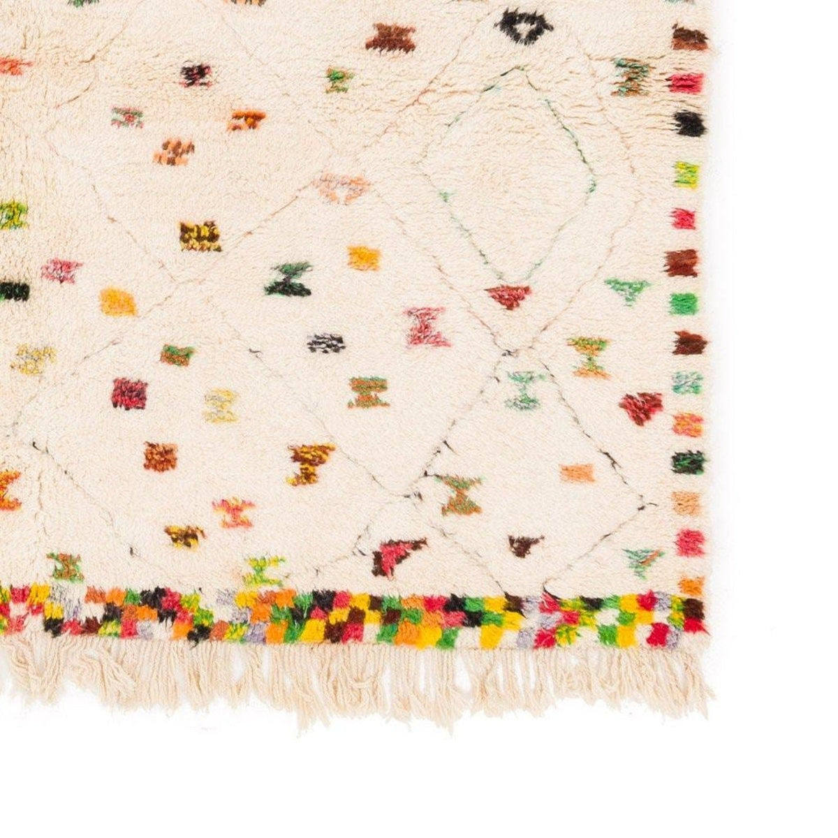 Detail view of a colorful patterned rug featuring fringe edges and colorful dots.