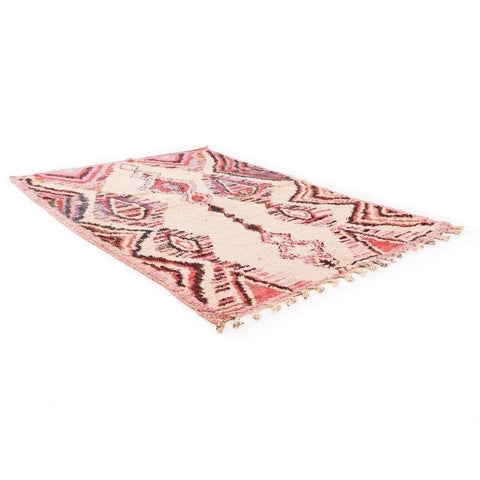 Lifestyle shot of the large pink geometric Azilal Moroccan rug in a studio setting.