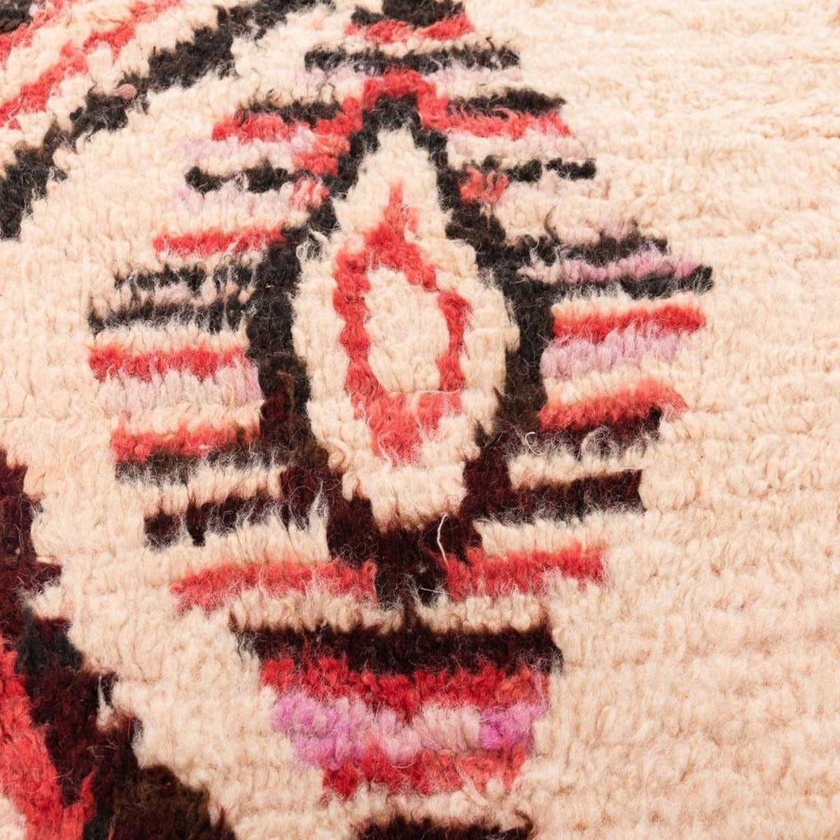 Detail of the Azilal rug fabric showing twisted fibers and colorful patterns.
