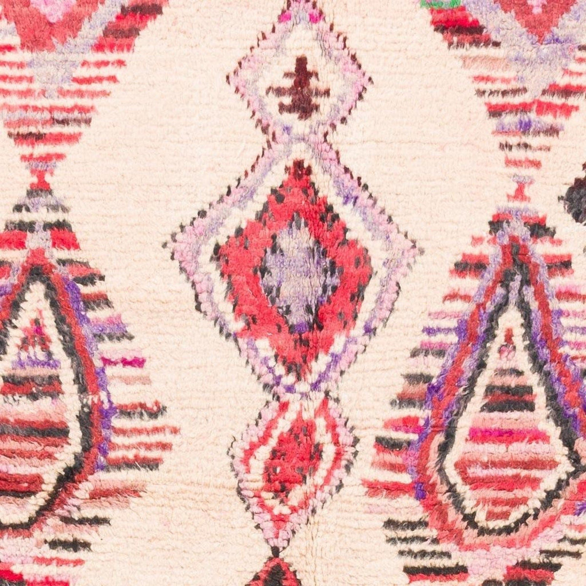 Close-up detail of the Azilal rug showcasing intricate designs in pink, cream, red, and purple.