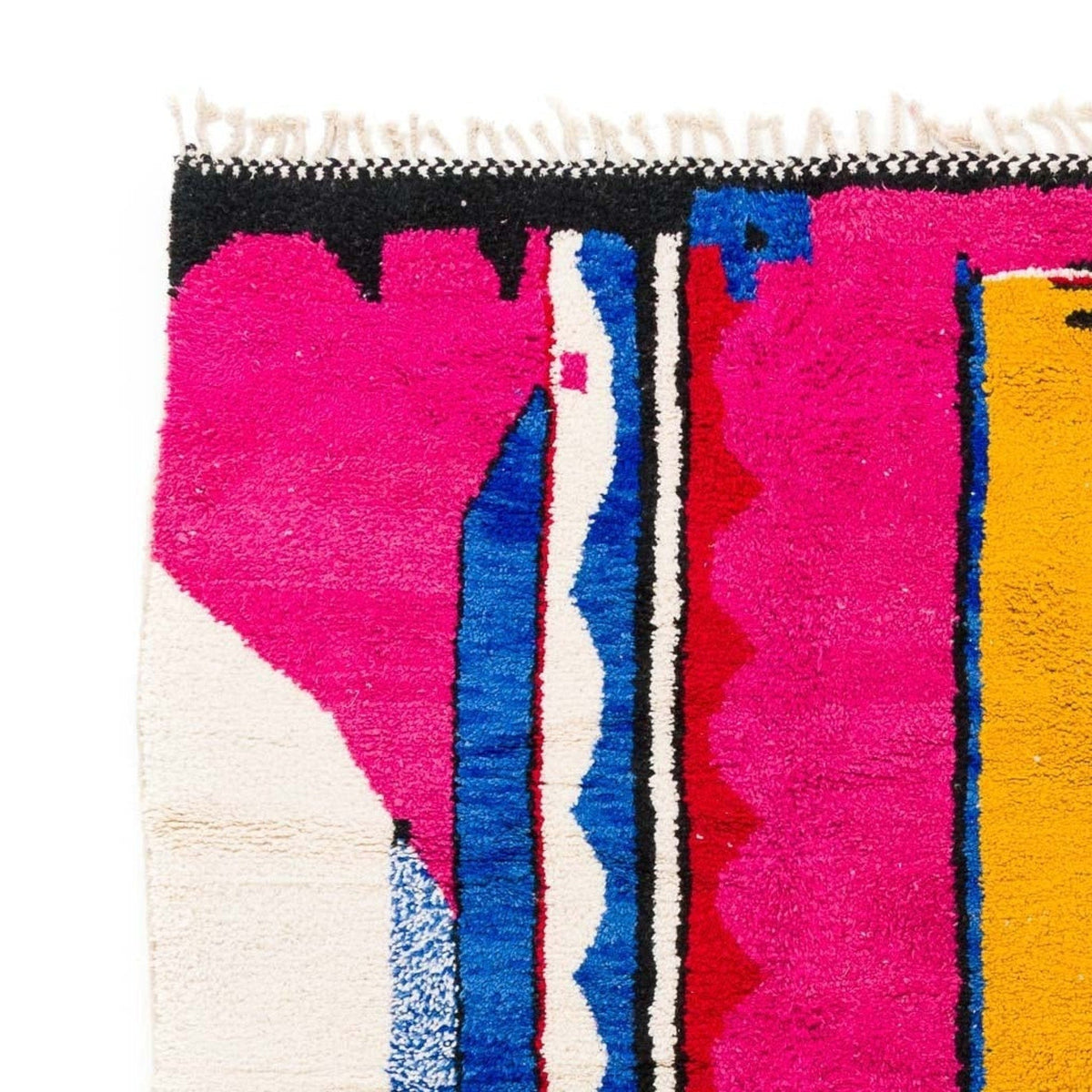 Side view showcasing fringe detail of the Azilal Moroccan rug with tribal patterns in pink and blue.