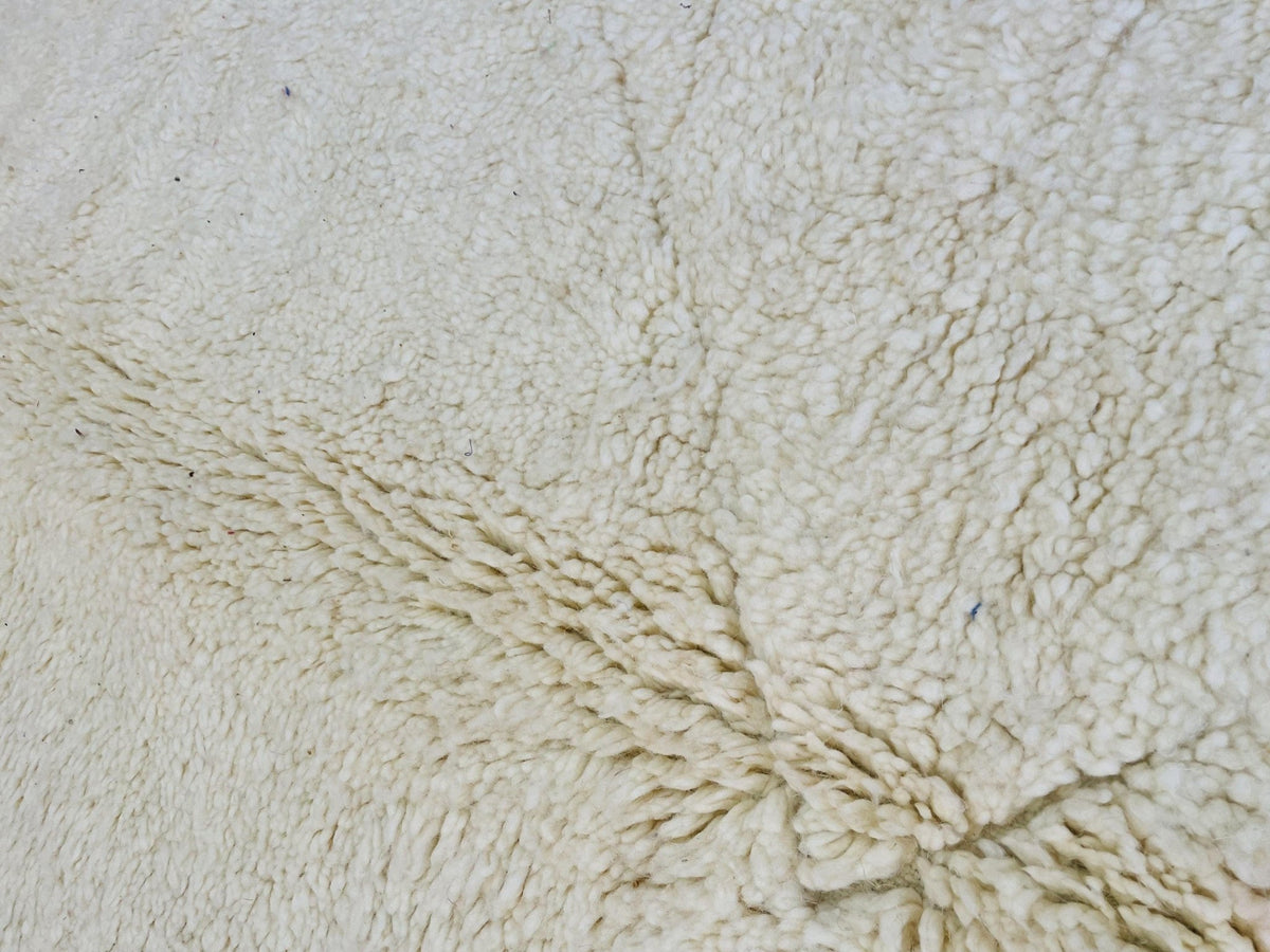 Front view of a cream and beige Moroccan rug showcasing a soft texture in a studio backdrop.