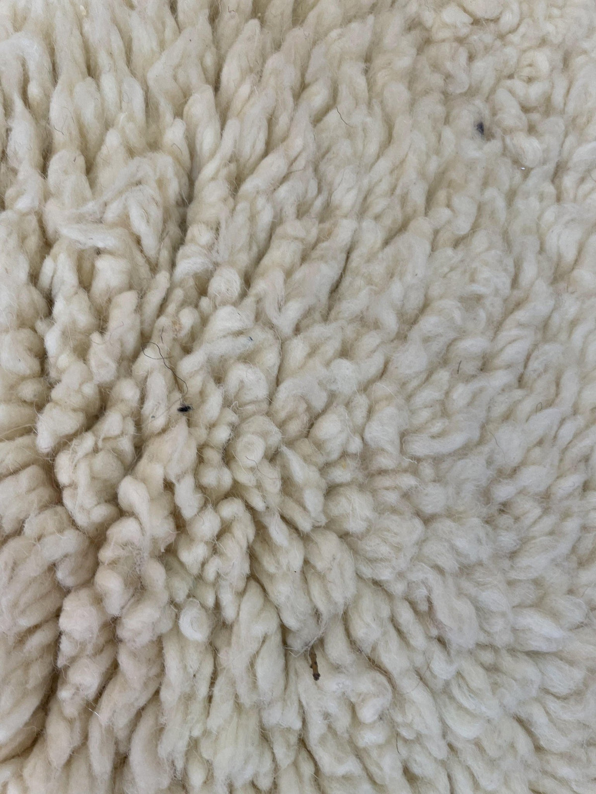 Detail close-up of the texture and pattern of a beige Moroccan rug.