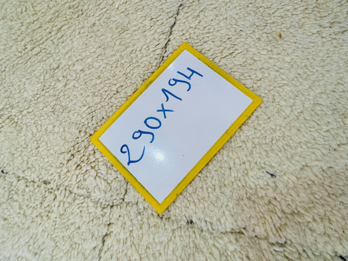Detail shot of a rug label with handwritten text on a white and yellow background.