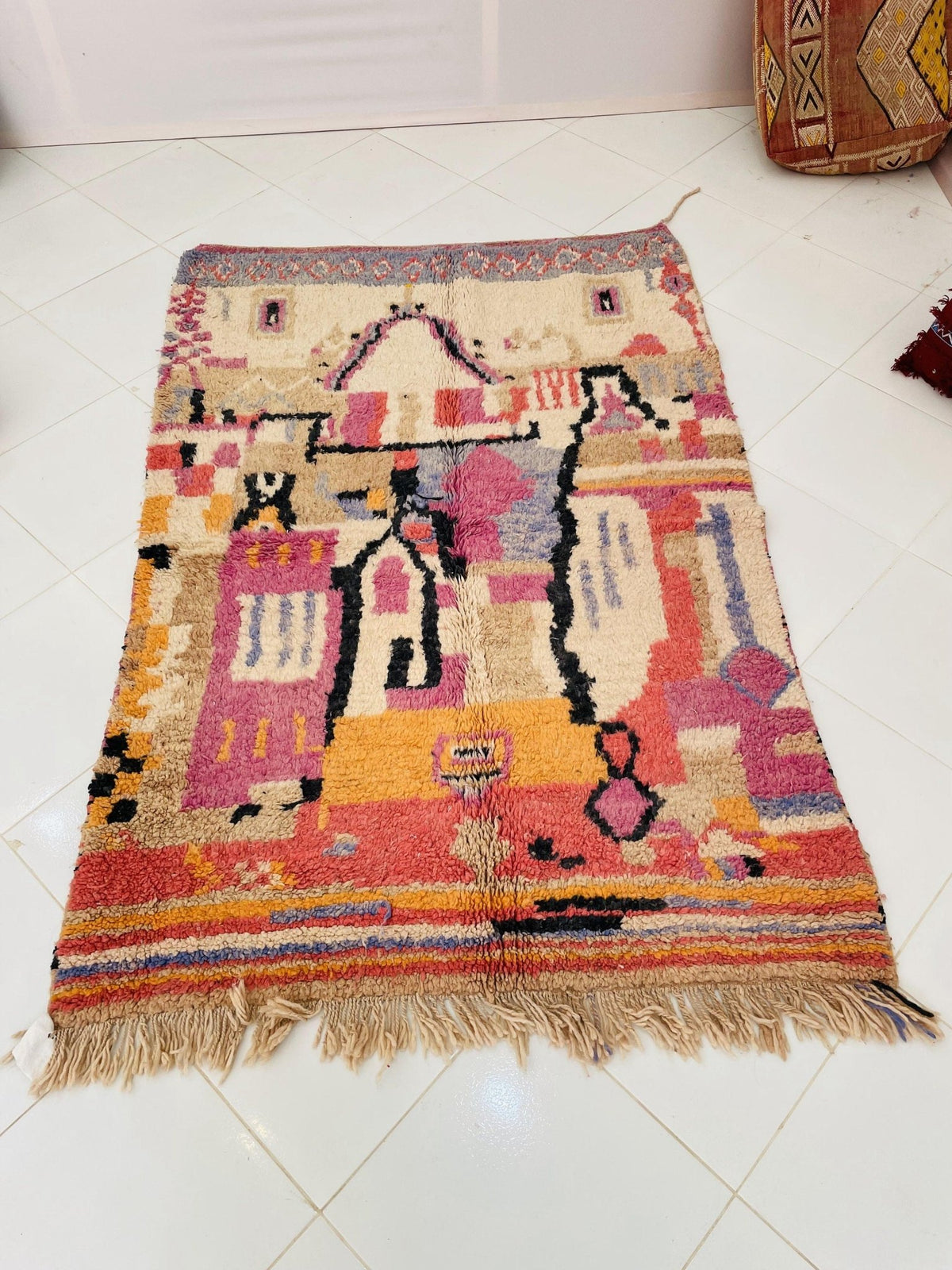 Front view of a vintage Moroccan rug showcasing red, yellow, and black colors with tribal patterns.