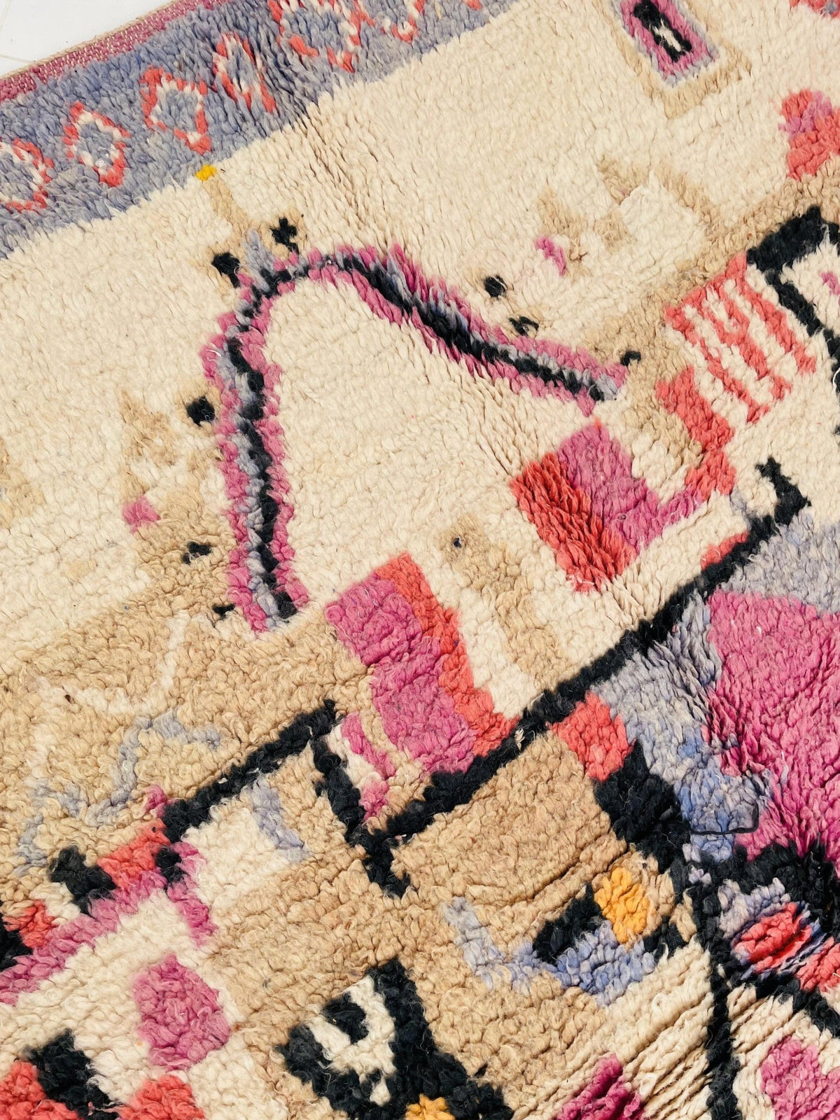 Close-up of a vintage Moroccan rug displaying colorful patterns and a textured weave.