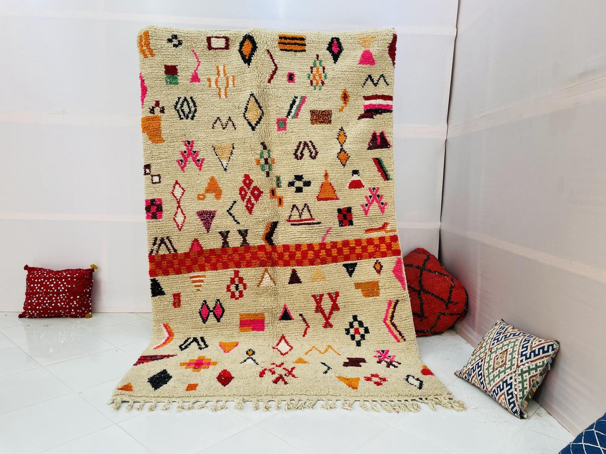 Lifestyle shot of a vintage Boujaad Moroccan rug featuring tribal patterns in beige, red, and orange.