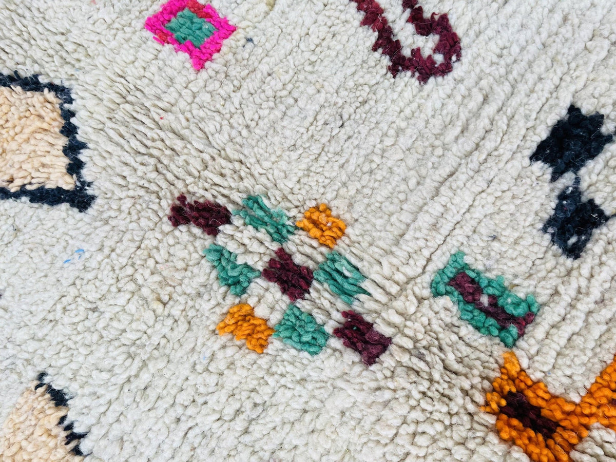 Detail shot of a vintage Boujaad Moroccan rug showcasing tribal patterns in red, orange, and white.