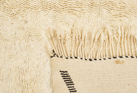 Close-up detail of the textured surface of the cream geometric line rug with geometric lines.