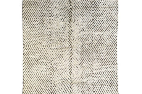 Detail close-up of the soft gray textured Moroccan rug showcasing its black and off-white pattern and fringe edges.