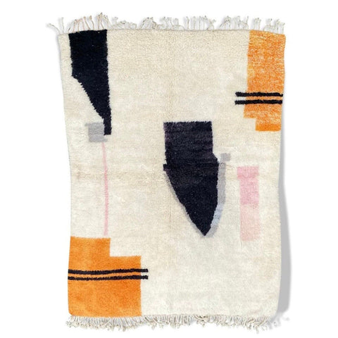 Detail close-up of the abstract design rug featuring geometric patterns in black, orange, and white.