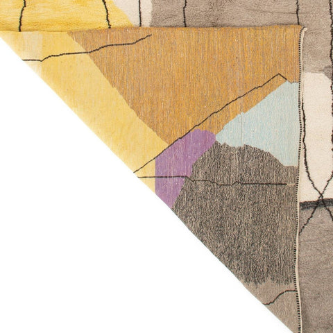 Detail close-up showing the geometric pattern of the gray, black, and mustard abstract rug.