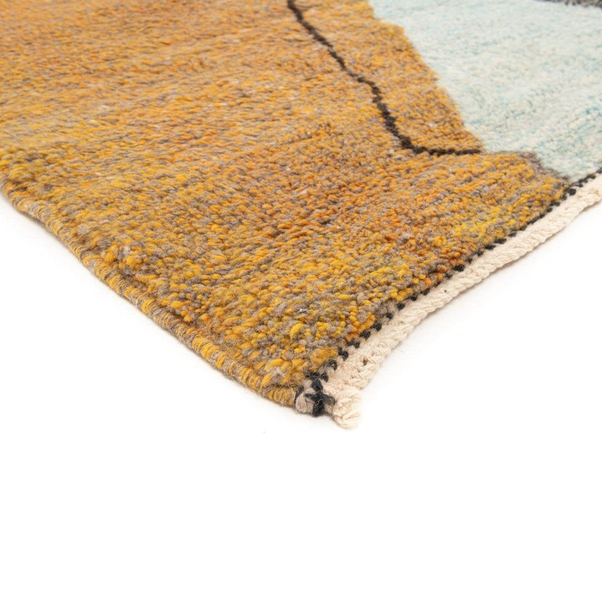 Detail close-up of the textured surface of the gray, black, and mustard abstract rug.