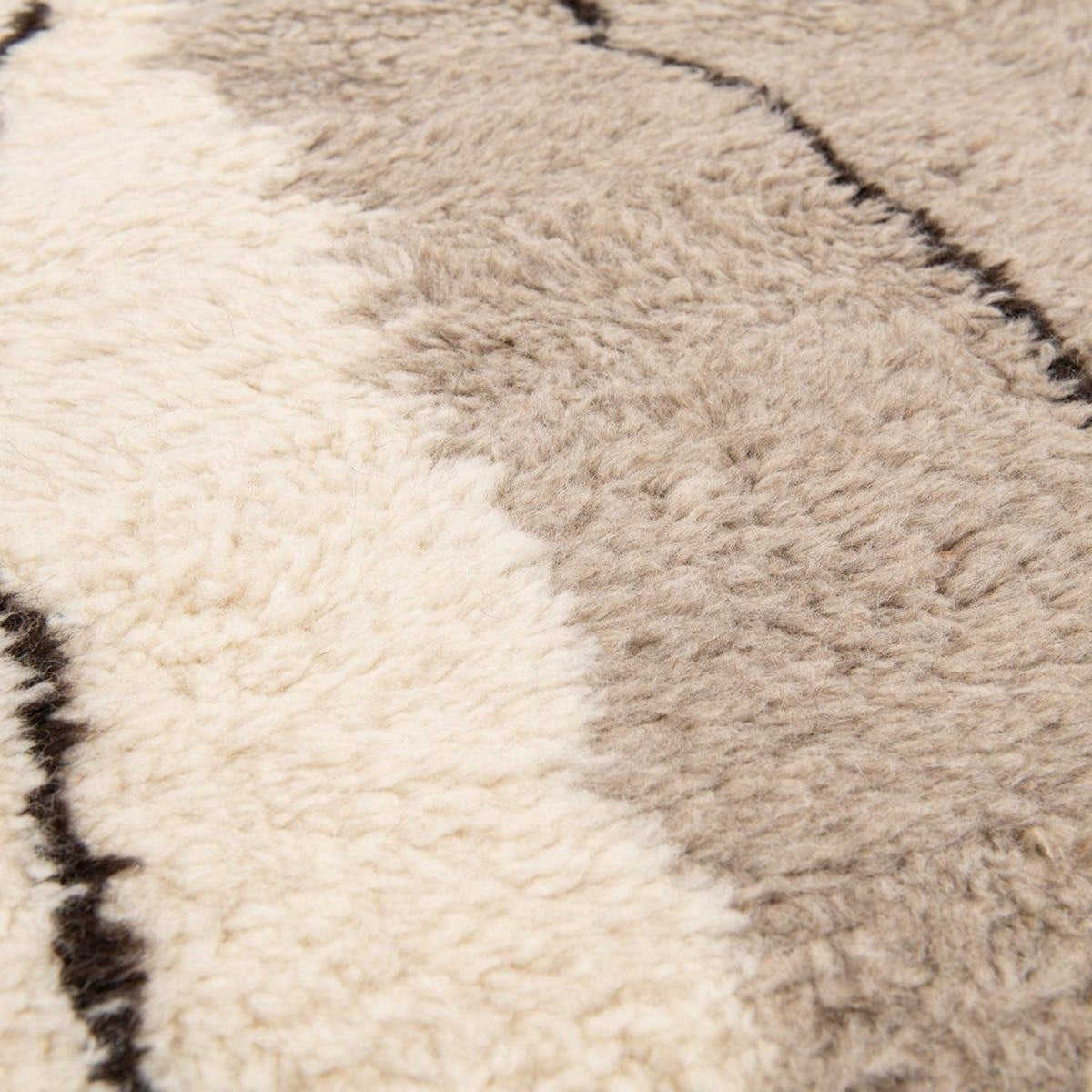 Side view of the gray, black, and mustard abstract rug highlighting its geometric design.