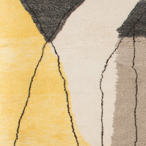 Detail close-up of the geometric pattern on the gray, black, and mustard abstract rug.