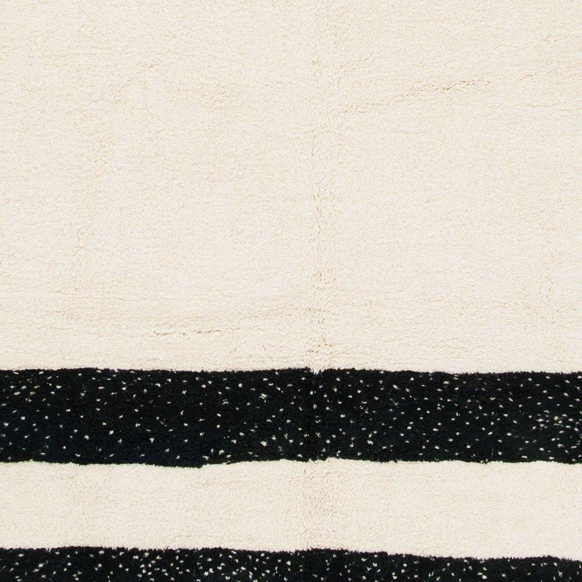 Detail view of the black and cream striped Moroccan rug with a striped pattern and soft texture.