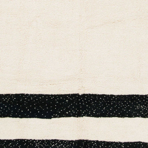 Detail view of the black and cream striped Moroccan rug with a striped pattern and soft texture.
