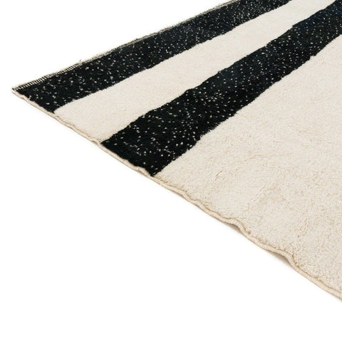 Detail close-up of the black and cream striped Moroccan rug showcasing its handmade design.
