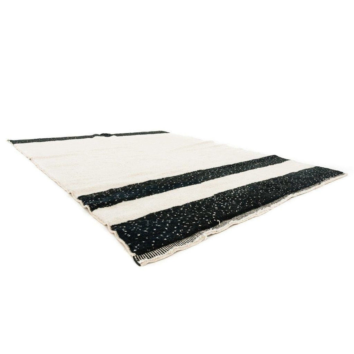 Side view of the black and cream striped Moroccan rug highlighting its textured surface.